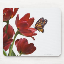 a bouquet of red tulips is visited by a monarch mouse pad