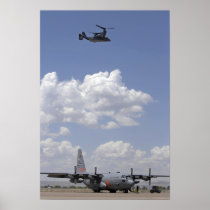 A CV-22 Osprey flies over a C-130 Hercules