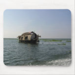 A houseboat moving placidly through a coastal lake mouse mats