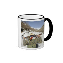 A Mujahadeen Guard walks with US Military membe Mugs