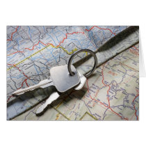 A set of car keys on a pile of road maps. greeting card