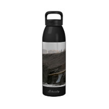 A surfboard sits on the beach in Florida on cliff Water Bottle