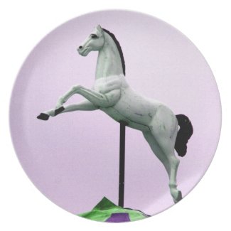 A white horse carousel statue against purple plate