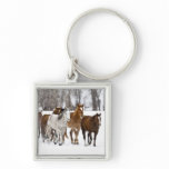 A winter scenic of running horses on The 2 Keychains