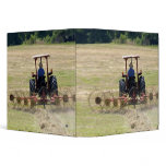 A young boy driving a tractor harvesting 3 ring binder