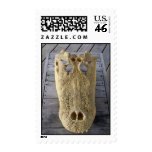 Alligator skull on wooden deck, gator head postage stamp