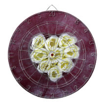 Artificial white cream flower on purple background dartboard with darts