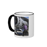 Aviation fuel technician attaches a fuel line coffee mug