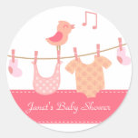Baby clothes hanging on clothesline with pink bird stickers