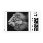 baby feet in father's hands postage