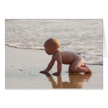 Baby playing in the sand on the beach card