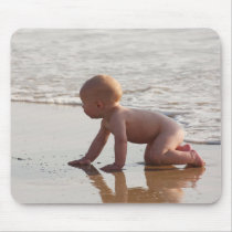 Baby playing in the sand on the beach mousepads