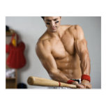 Baseball player with bare chest warming up with post cards