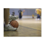 Basketball player holding ball with feet post card