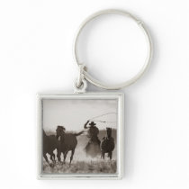 Black and White photo of a Cowboy Lassoing Horses Key Chain