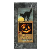 Black cat on a wooden fence with pumpkin picture card