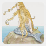 Blonde mermaid sitting on sea rock, side view. sticker