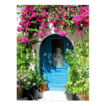Blue door framed with beautiful bougainvillea postcards