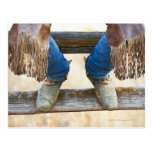 Botas de vaquero en la cerca postal