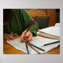 Boy concentrating on math homework posters