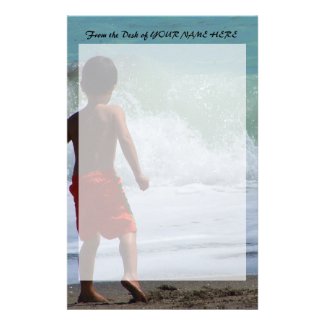 boy on beach playing in water stationery paper