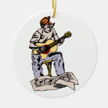 Boy playing acoustic guitar with sheet music christmas tree ornaments