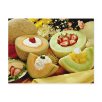 Cantaloupes and melons on cutting board with flowe postcard