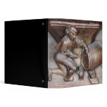 Carving depicting a man putting a tap on barrel binders