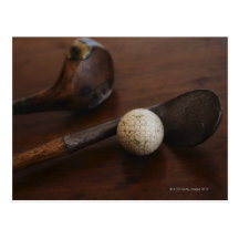Close up of antique golf clubs and golf ball post cards