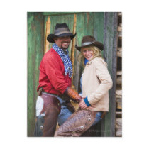 Cowboy and cowgirl holding hands in front of an postcard