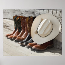 Cowboy hat on row of cowboy boots outside a log posters