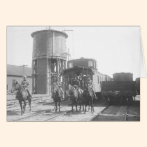 Cowboys on horses posing in front of a train cards
