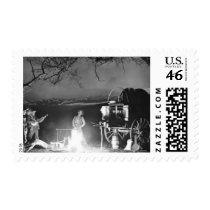 Cowboys playing and singing around a campfire postage stamp