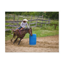 Cowgirl on horseback practicing barrel racing in post cards