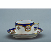 Cup and saucer with colorful designs cut out