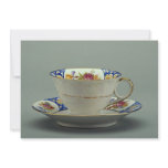 Cup and saucer with colorful flower designs on it. invite