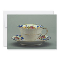 Cup and saucer with colorful flower designs on it. invite