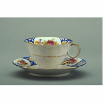 Cup and saucer with colorful flower designs on it. acrylic cut outs