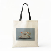 Cup and saucer with colorful flowers on it. bags