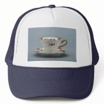 Cup and saucer with colorful flowers on it. mesh hats