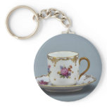 Cup and saucer with colorful flowers on it. key chains
