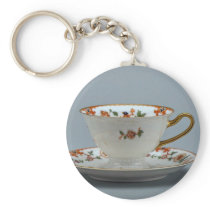 Cup and saucer with colorful flowers on it. keychains