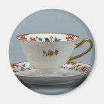 Cup and saucer with colorful flowers on it. fridge magnet
