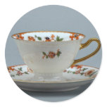 Cup and saucer with colorful flowers on it. round stickers
