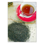 Cup of black tea with tea leaves greeting card