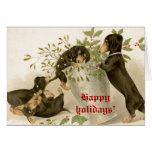 Dogs playing with Christmas mistletoe & holy berry Cards