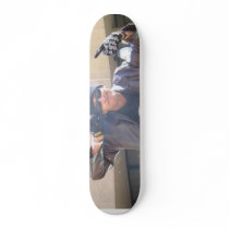 Evan in a leather jack and skull cap skateboards