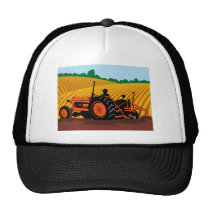 farmer driving farm tractor plowing field hat