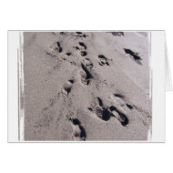Foot prints in wet beach sand towards viewer card