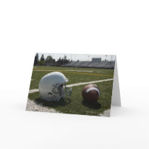 Football and football helmet on football field greeting cards